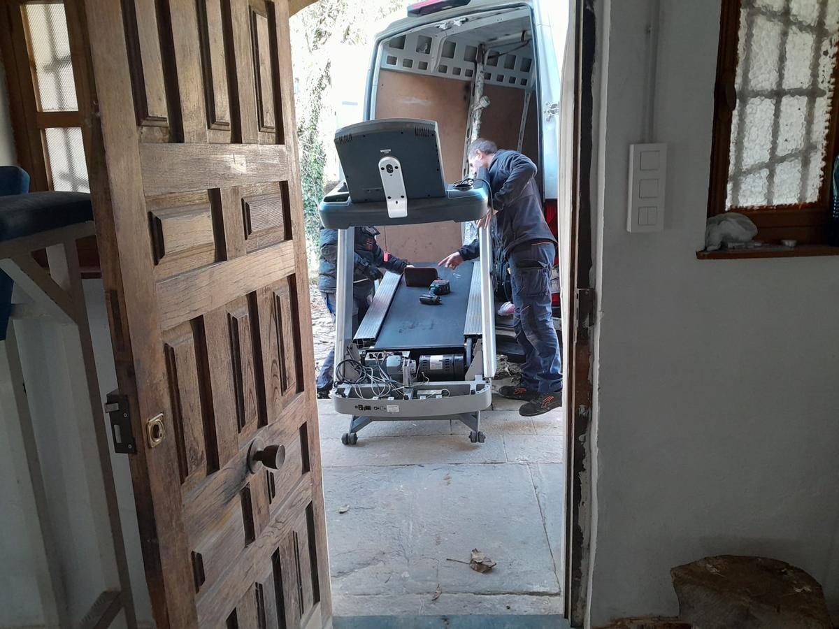 Dos trabajadores meten una máquina de correr en la rectoral.