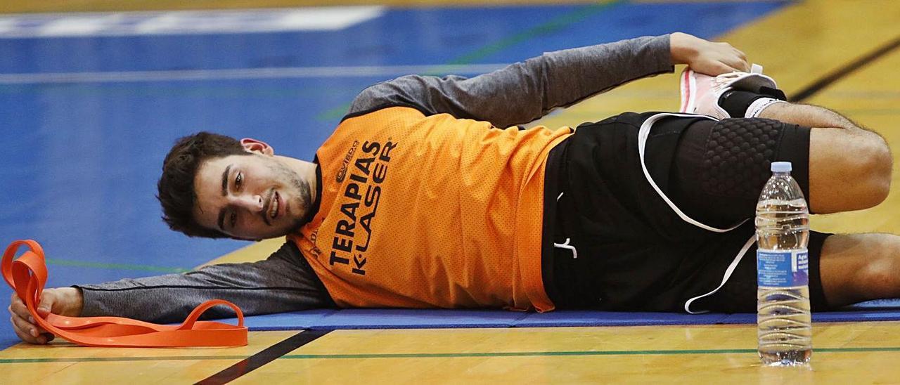 Alonso Meana realiza ejercicios de calentamiento durante un entrenamiento en el polideportivo de Pumarín.