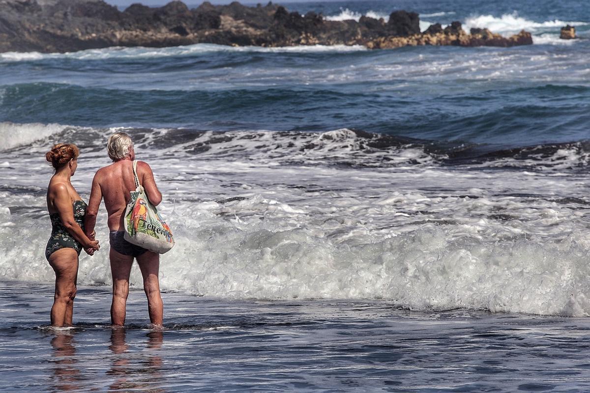Dos personas otean el mar en playa Jardín, en Puerto de la Cruz