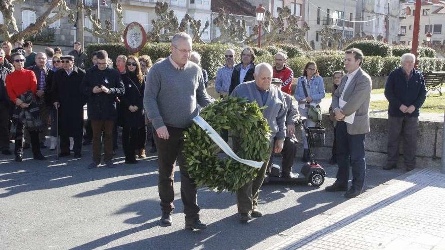 Manuel Mosteiro y Manuel López con la corona en memoria de Johán Carballeira. // S.Á.