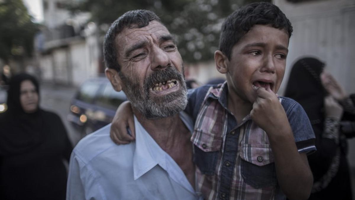 El padre y el hermano de dos de los niños asesinados en un bombardeo israelí, ayer en Gaza.