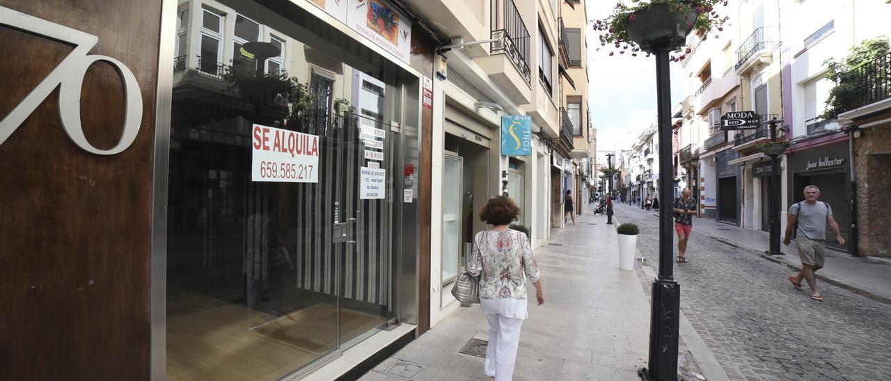 Una mujer pasa frente al escaparate de una tienda de la calle Alloza de Castellón con el cartel de &#039;Se alquila&#039;.