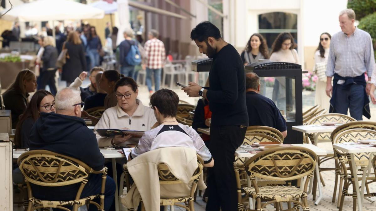Un camarero atiende a sus clientes en establecimiento de hostelería de Málaga capital.