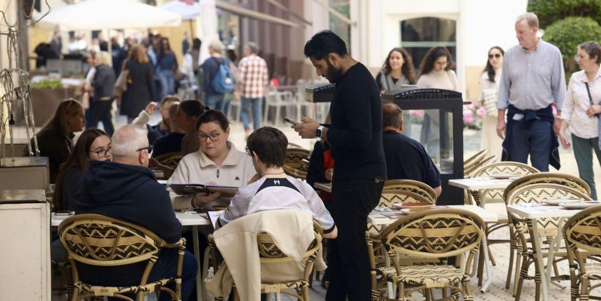 Un camarero atiende a sus clientes en establecimiento de hostelería de Málaga capital. | ÁLEX ZEA