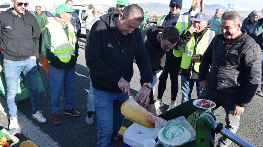 Agricultores almuerzan sobre el asfalto en Archena este jueves durante la protesta del campo murciano