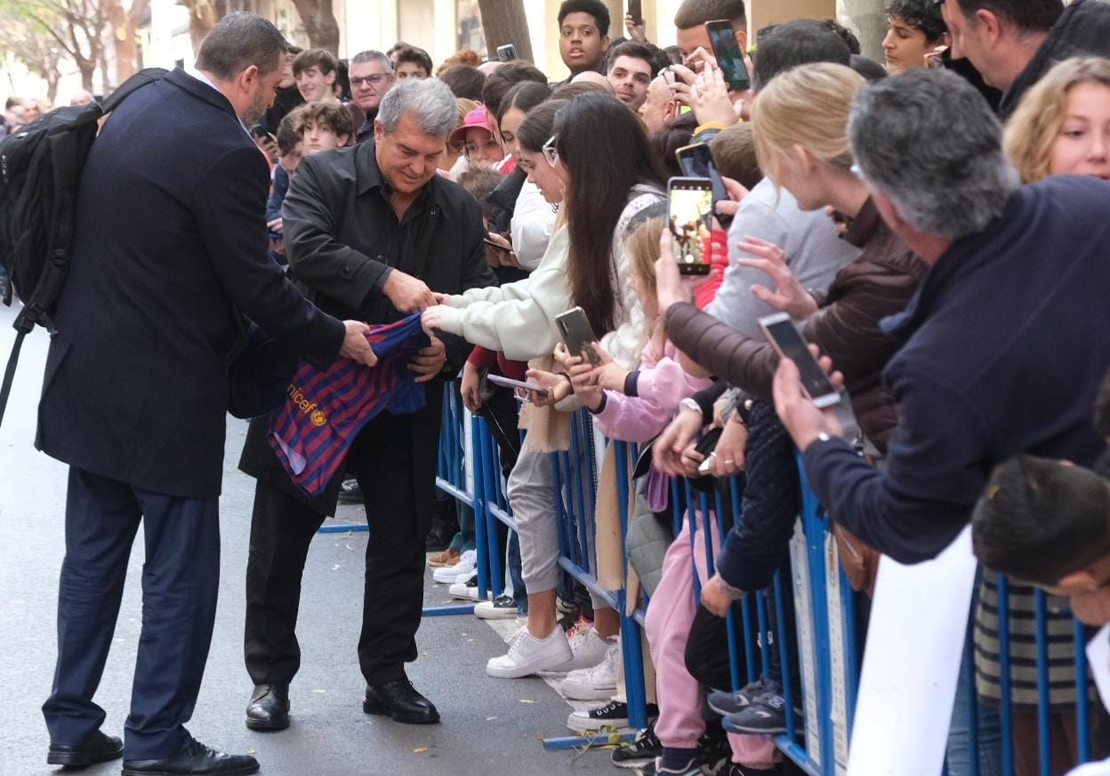 Laporta firma las camisetas de varios aficionados concentrados frente al hotel en el que se alojará el Barça en Alicante