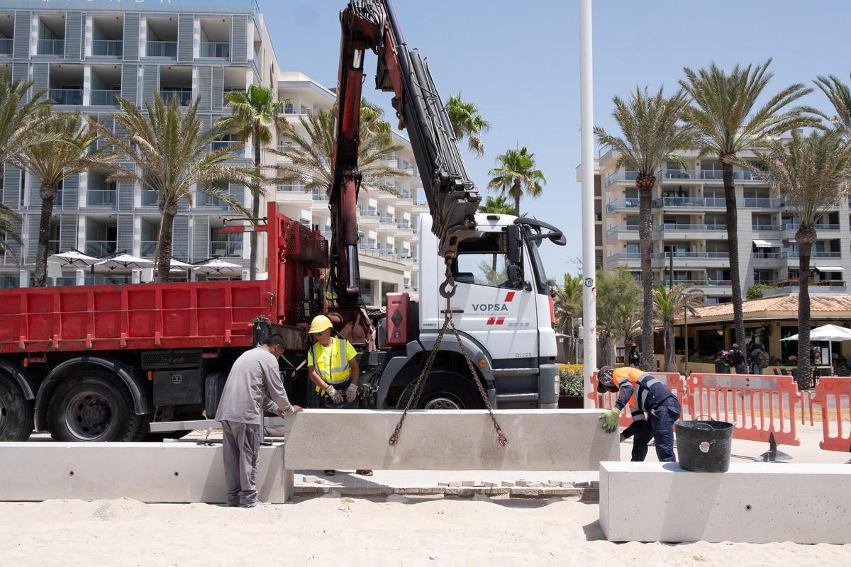 Operarios descargan uno de los módulos de hormigón que conforman el nuevo murete