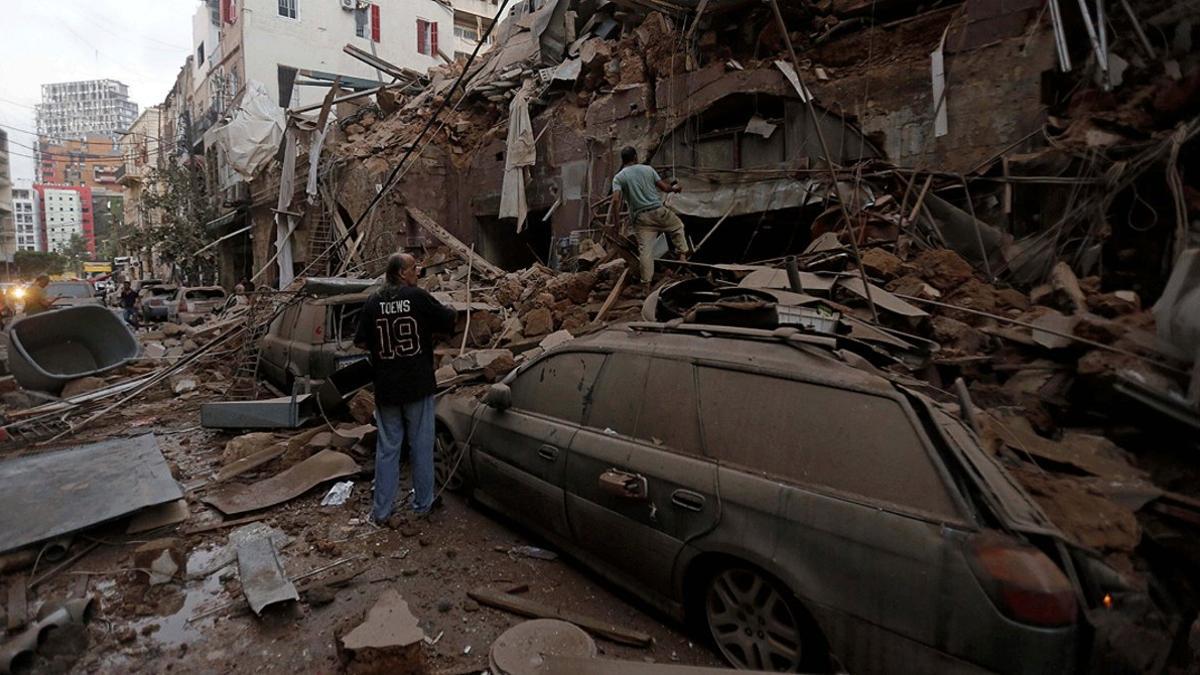 Varios vecinos inspeccionan los restos de un edificio arrasado por la explosión, en Beirut, este miércoles 5 de agosto