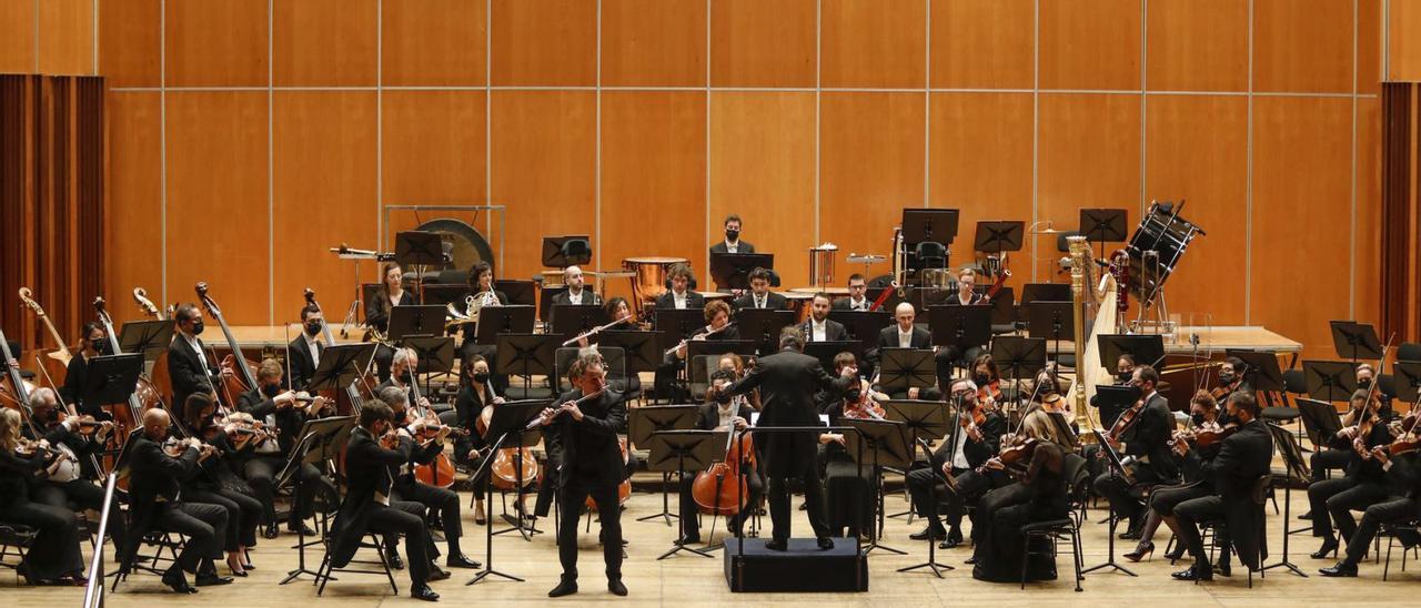 La Orchestre de la Suisse Romande en plena actuación, ayer, en el Auditorio de Oviedo, con el flautista Emmanuel Pahud. En el recuadro, el público asistente al concierto. | Luisma Murias