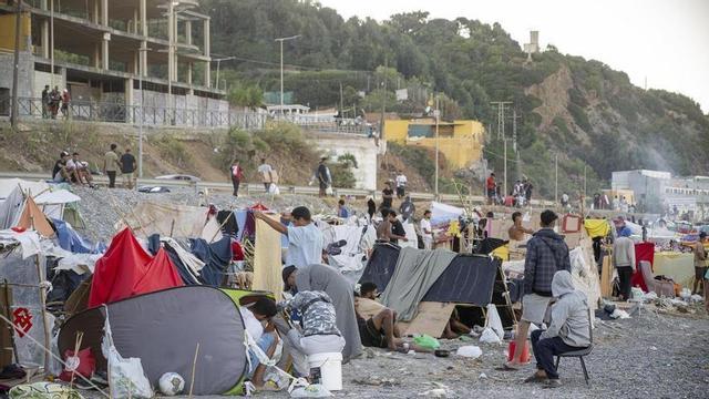 Desenes de persones viuen i passen la nit a la platja del Trampolín, a Ceuta, on encara hi romanen centenars d’immigrants en situació irregular, que han tornat a construir barraques