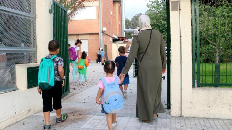 Una mare acompanya als seu fills a escola, ahir al matí