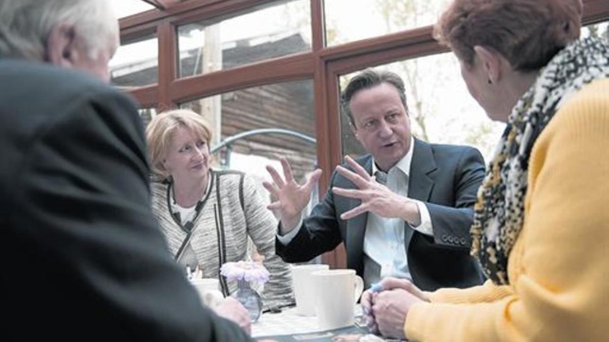 Cameron habla con votantes en el Secret Garden Café de Manchester.