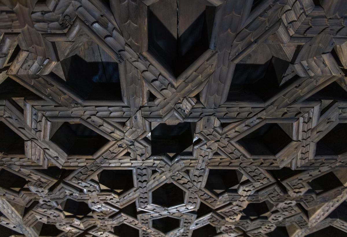 Destaca un diseño llamativo con motivos geométricos y estrellas de ocho puntas talladas en la madera