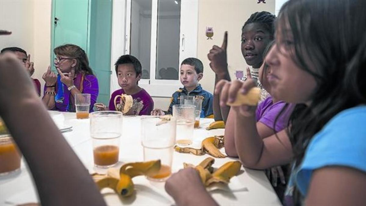 Hora de la merienda en un centro de Santa Coloma de Gramenet (Barcelonès), dentro del programa de apoyo educativo de la Creu Roja, esta semana.