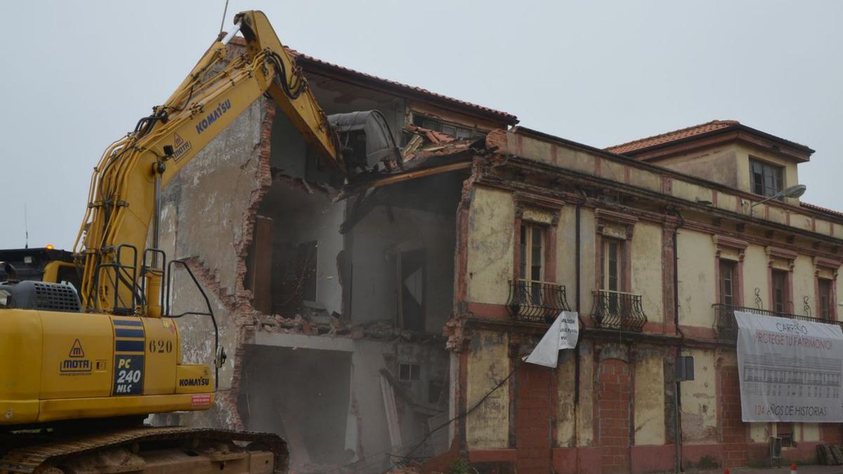 Una excavadora, ayer, durante la demolición de las Casas de Perán. | B. G.