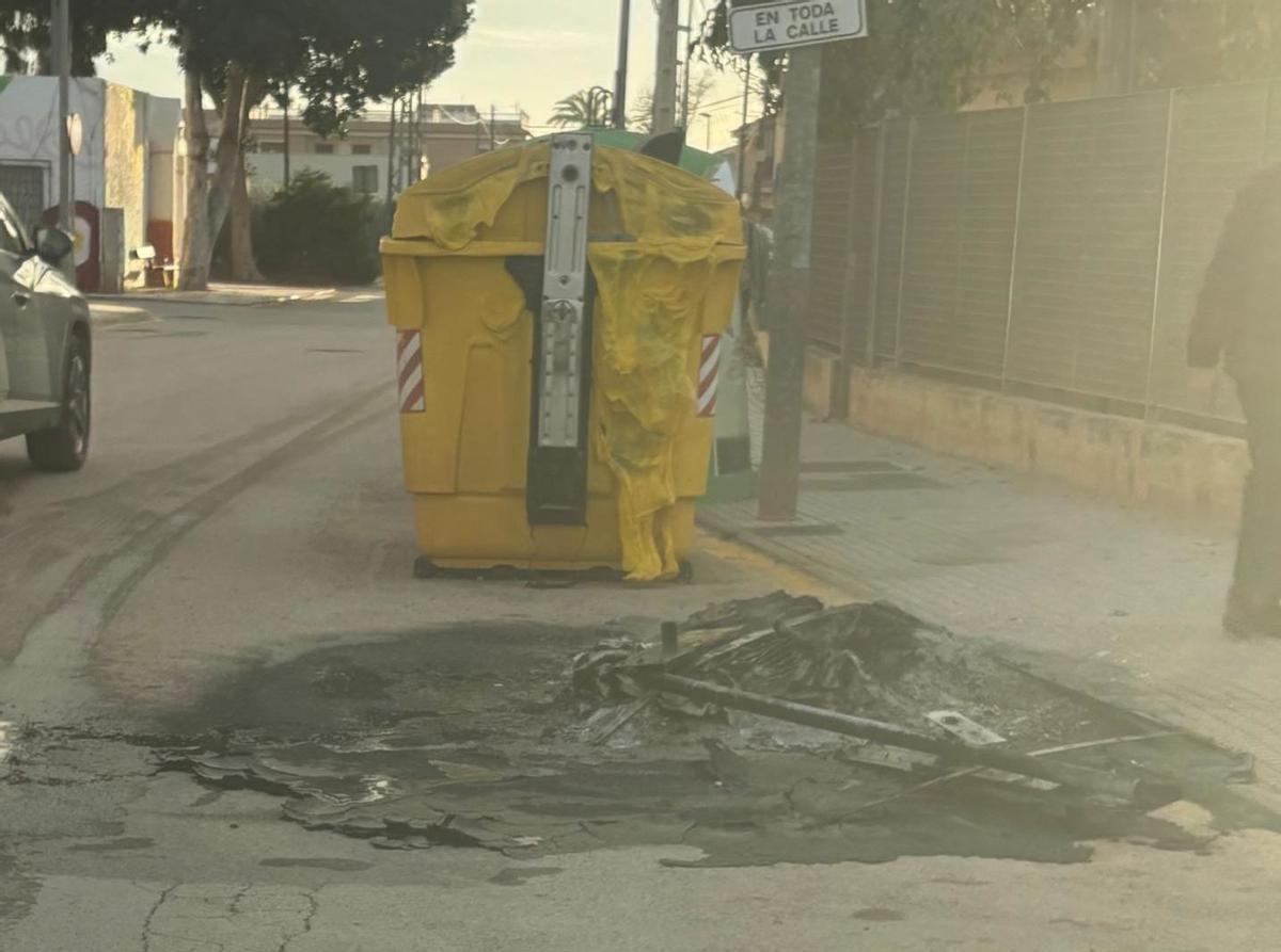 Restos del contenedor quemado este lunes en la puerta del instituto.