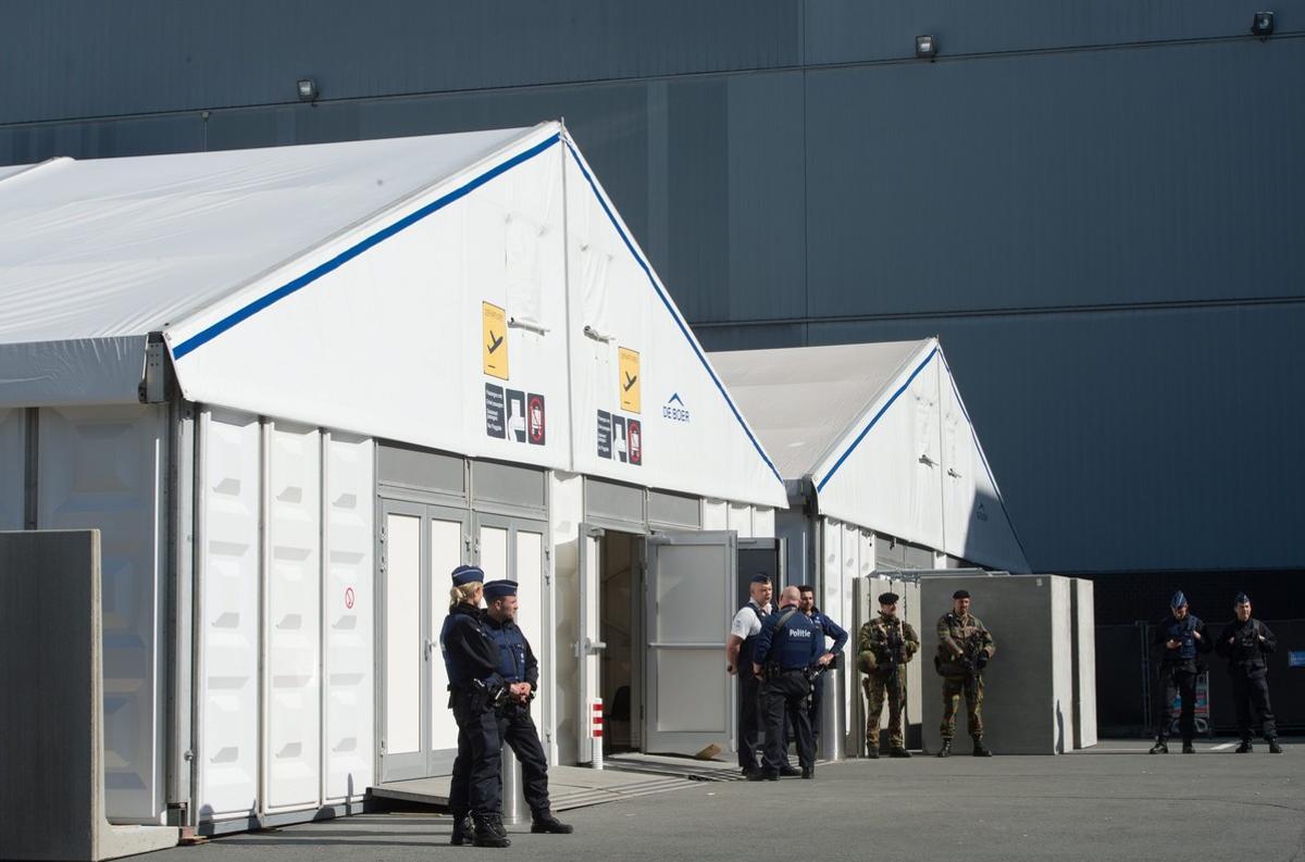 . Zaventem (Belgium), 03/04/2016.- Security officials stand outside the airport building as operations resume at Brussels Airport in Zaventem, near Brussels, Belgium, 03 April 2016. The airport was reopened after the terror attacks of 22 March, when at least 31 people were killed and hundreds injured in bombs explosions at the departures hall of the airport and at Metro stations in downtown Brussels. Militants of the so-called Islamic State (IS) have claimed responsibility for the attacks. (Bruselas, Bélgica) EFE/EPA/BENOIT DOPPAGNE/POOL