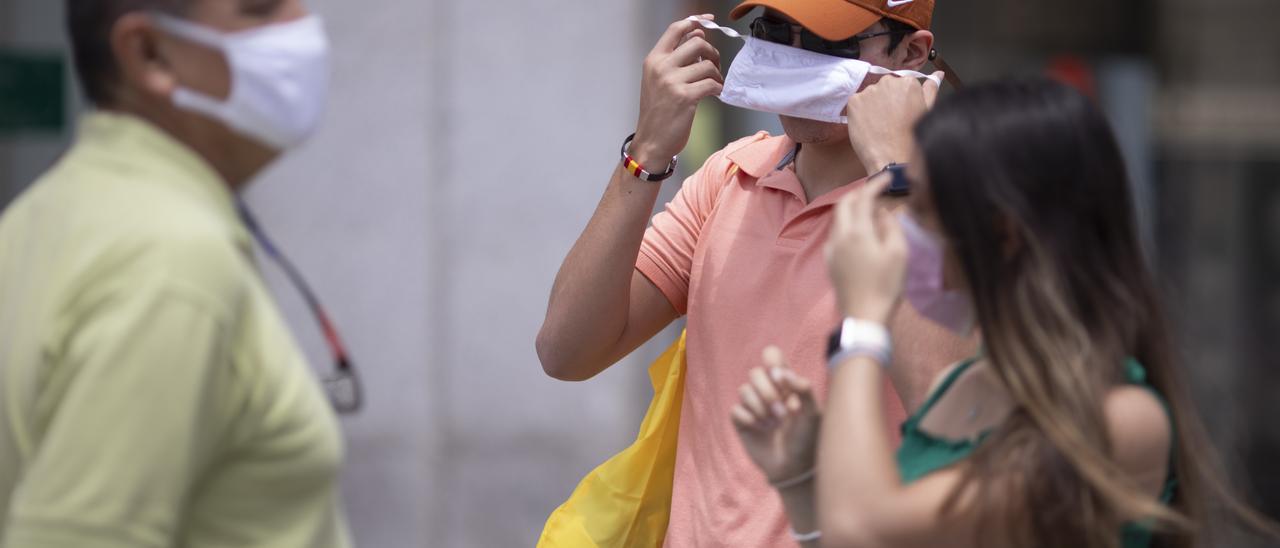 Un hombre se quita la mascarilla.