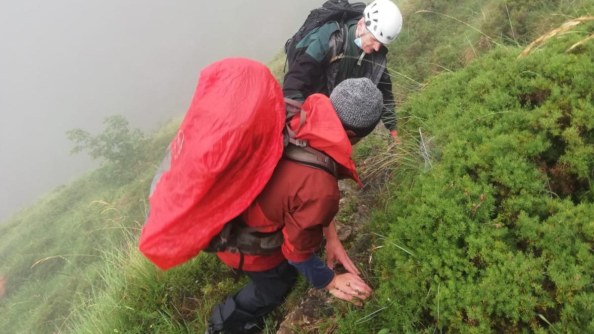 Un guardia de Montaña ayuda a uno de los rescatados.