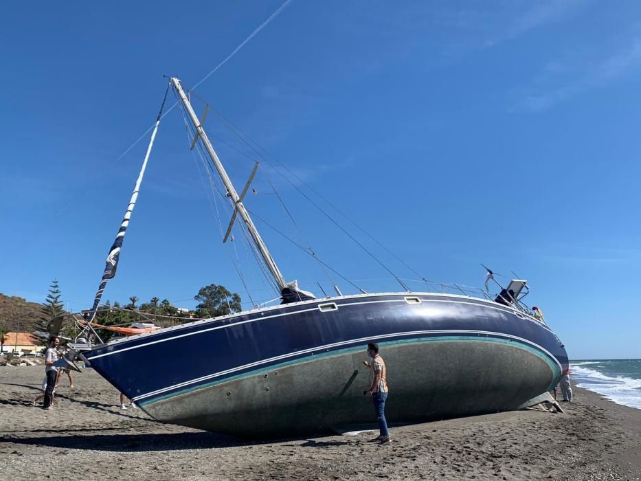 El velero Django quedaba varado en la playa de Benajarafe, el pasado viernes. A la espera de ser remolcado, el barco se ha convertido en una atracción para paseantes y bañistas, que fotografían la peculiar estampa.