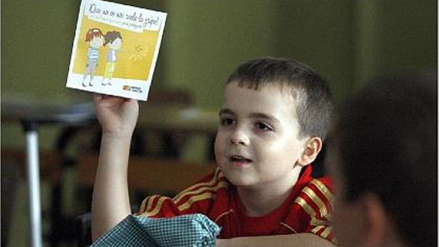 Un nen juga amb un tríptic informatiu sobre la nova grip en una escola de Saragossa.