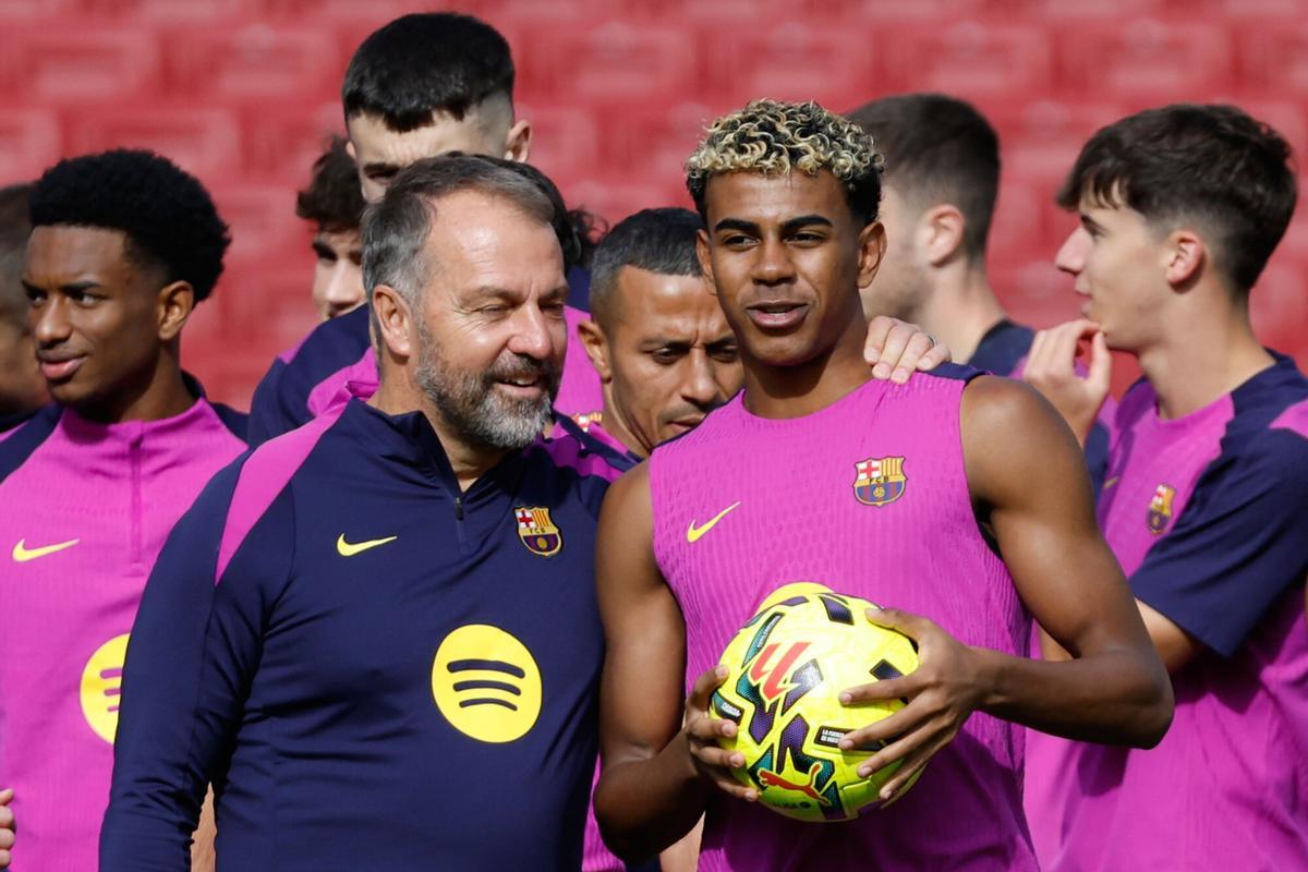 Barcelona's Lamine Yamal, centre right, talks with head coach Hansi Flick during the team's first training session at at the Camp Nou stadium after its renovation in Barcelona, Spain, Friday, Nov. 7, 2025, . (AP Photo/Joan Monfort)