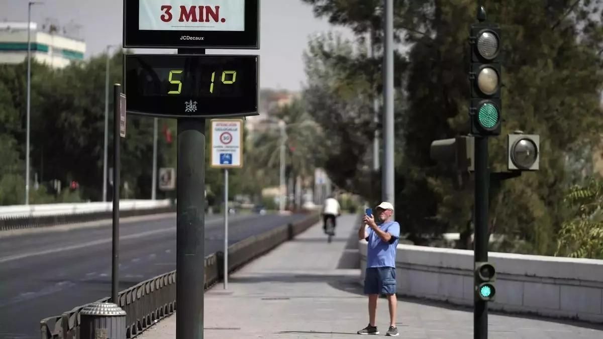 Un hombre fotografía un termómetro durante una ola de calor en Córdoba.