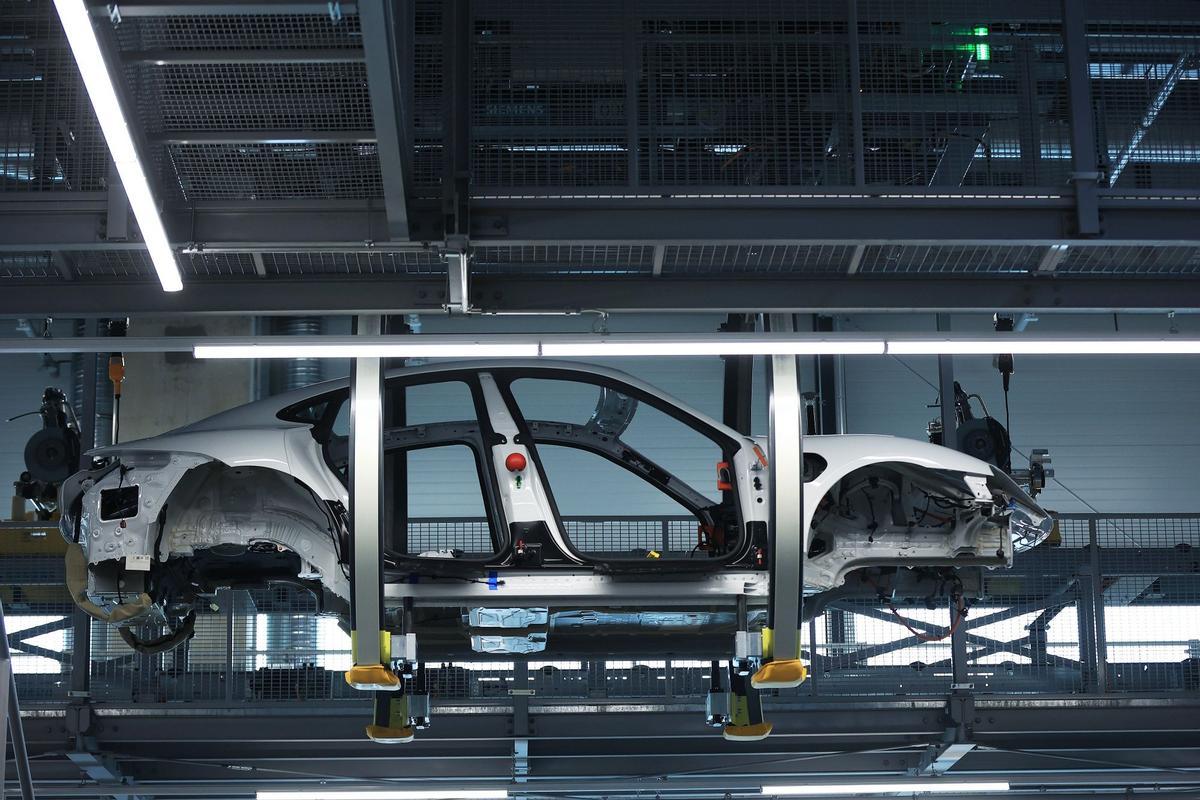 Los empleados trabajan en las carrocerías de los automóviles de lujo Porsche Taycan totalmente eléctricos en la línea de producción de la fábrica de Porsche AG en Stuttgart, Alemania.