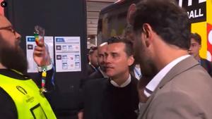 Montella muestra su acreditacióna pocos centímetros de la cara del guardia de seguridad.