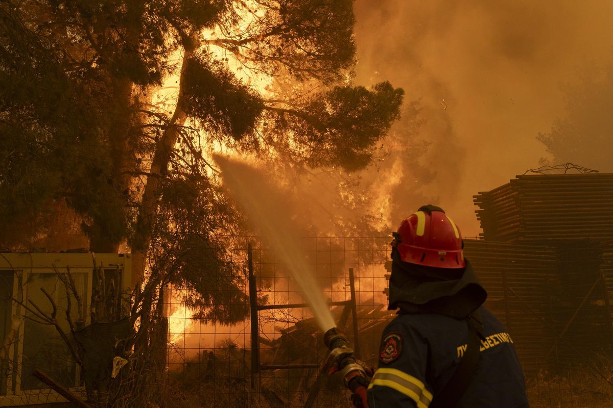 Un bombero lucha, en las labores de extinción del incendio en una zona del noreste de Atenas.