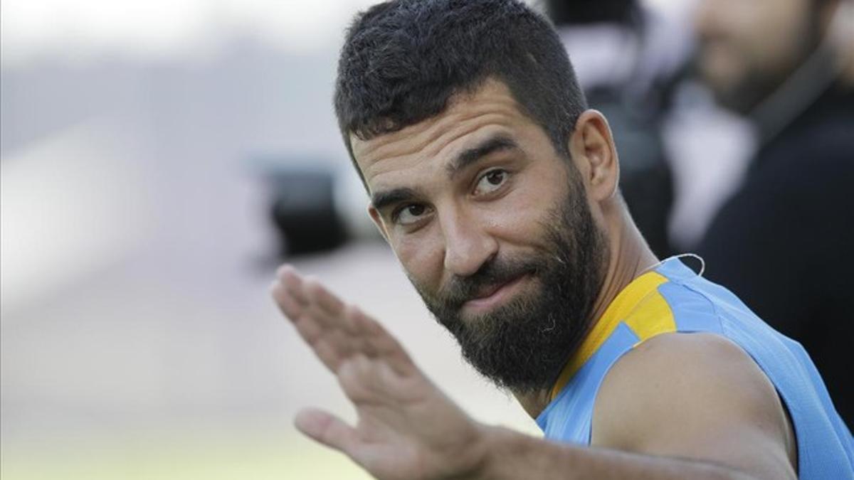 Arda Turan saluda al público antes de un entrenamiento del Barça.