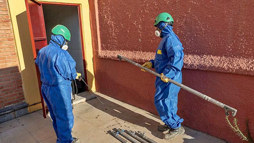 Operarios retiran material de un centro educativo.