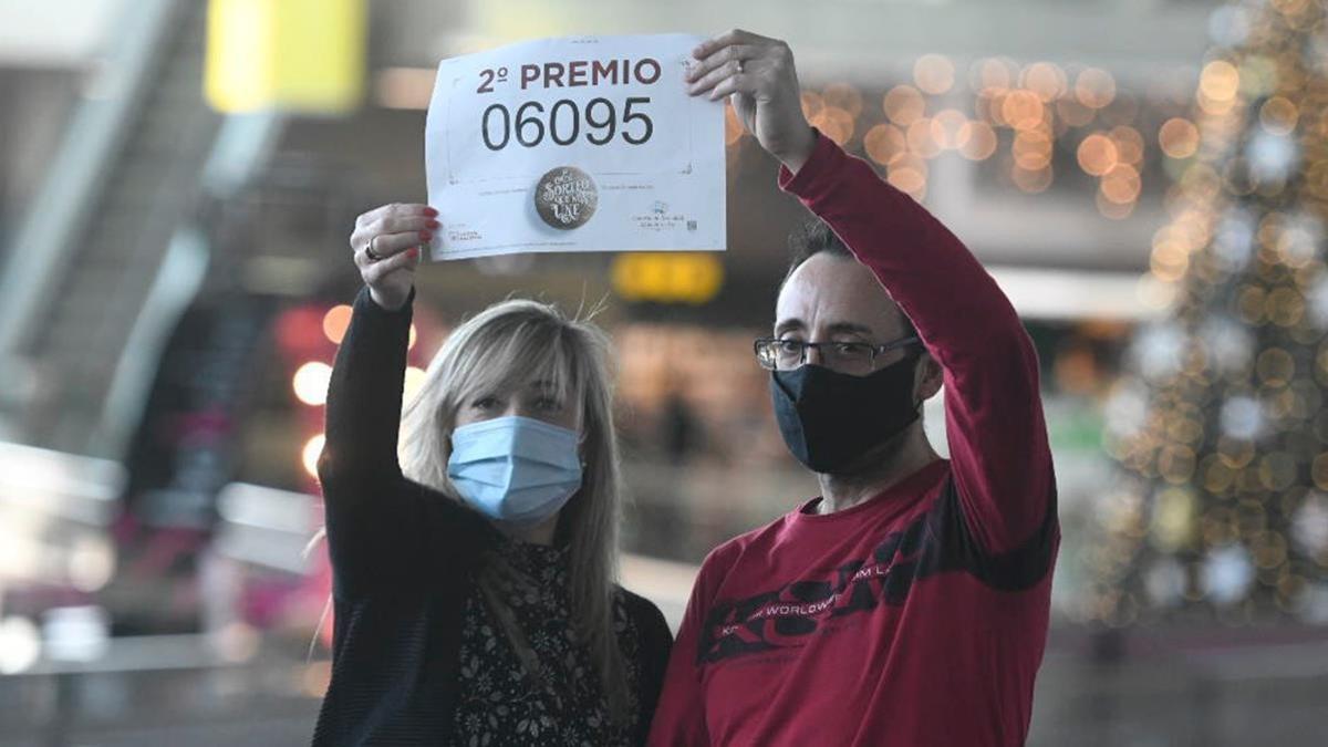 Ana y Miguel Ruiz sostienen el número premiado con el segundo premio de la Lotería de Navidad de las que vendieron dos series en su administración de Badalona.