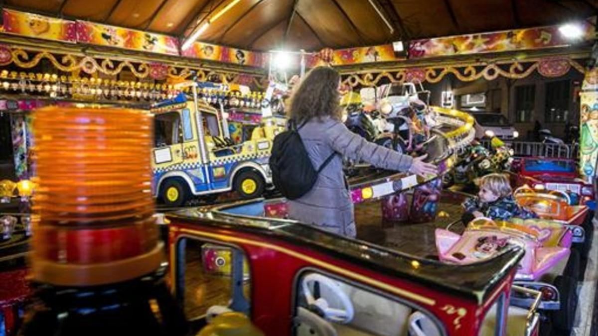 Un niño disfruta en una atracción de la feria instalada en la calle de Floridablanca, entre las de Entença y Rocafort de Barcelona, el pasado miércoles.