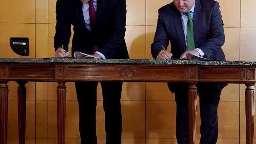 Pedro Sánchez y Andoni Ortuzar firman el acuerdo, ayer. // J.L. Roca