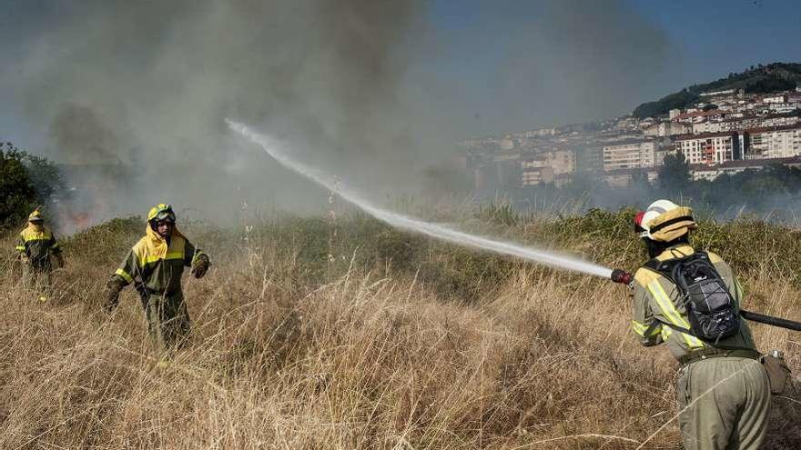 Efectivos de emergencia, ayer, durante la extinción del incendio en A Farixa (Ourense).