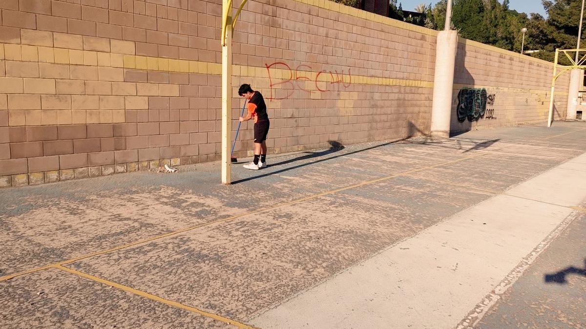 Un joven barre parte del polideportivo de Colonia Requena.