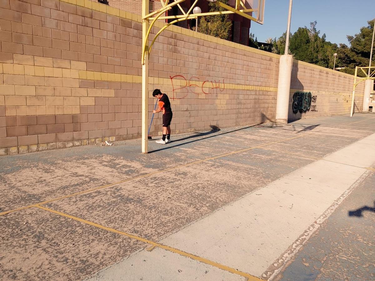 Un joven barre parte del polideportivo de Colonia Requena.