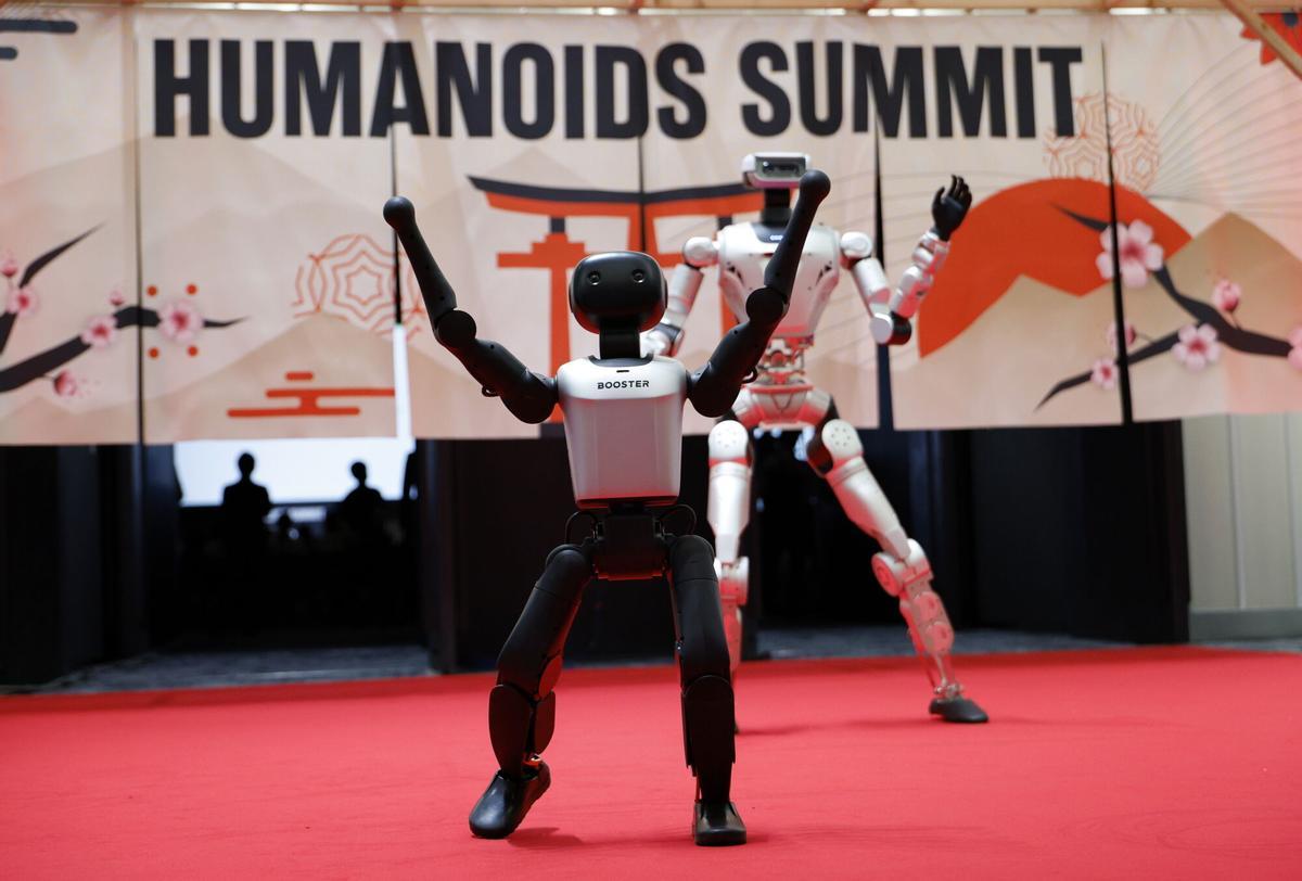 Los robots humanoides Booster K1 (al frente) y LIMX Oli realizan una danza durante la Cumbre de Humanoides en Tokio,