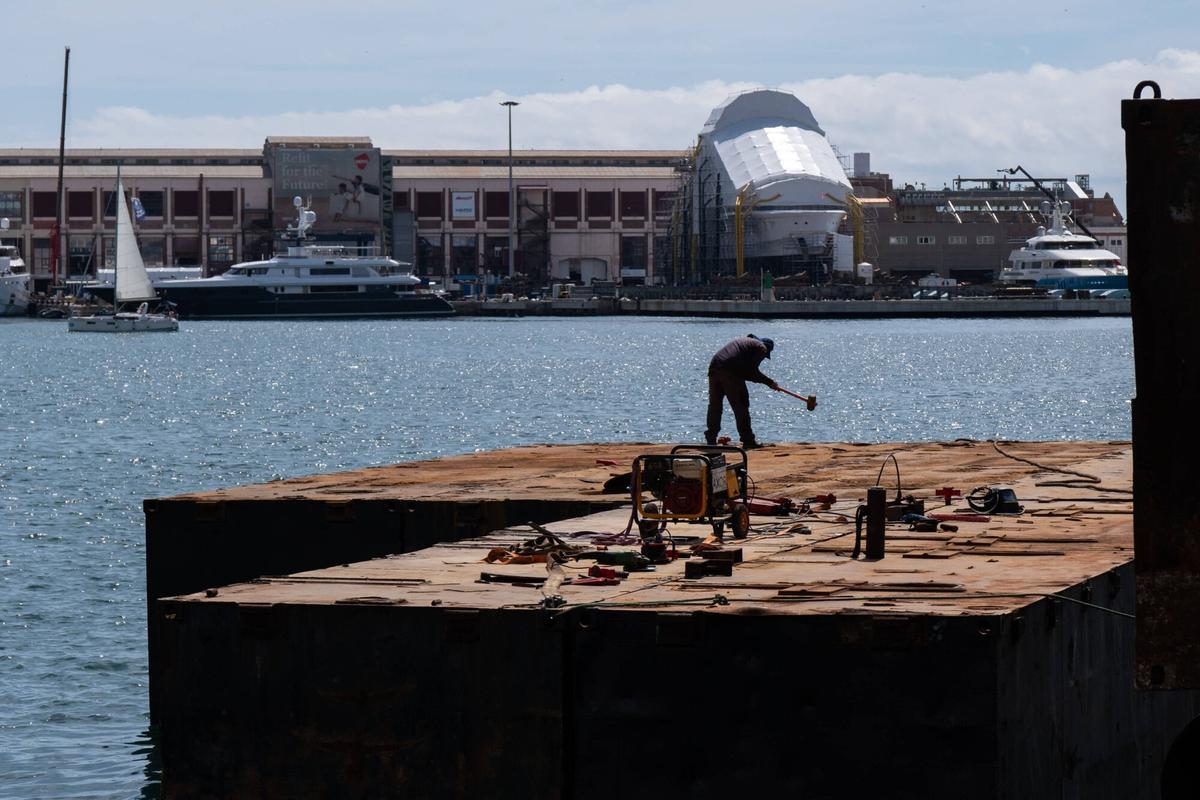 Operarios trabajando en el montaje del escenario sobre el mar del Blaumarí Music Festival, este jueves en el Port Vell.