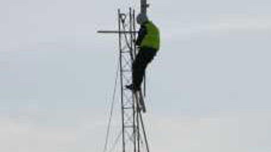 Labores de instalación de la antena. A la derecha, José María Tornel y la edil Pepa Meroño, en vía pública.