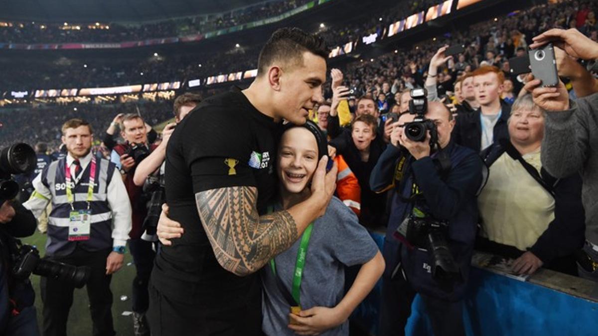 Un jugador de los 'All Blacks' da su medalla de campeón a un joven que saltó al campo