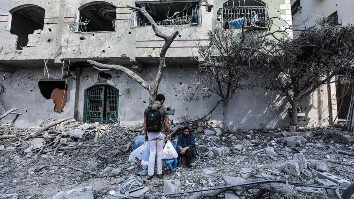 Palestinos en medio de los escombros del barrio Al  Ramal tras un ataque aéreo de Israel.