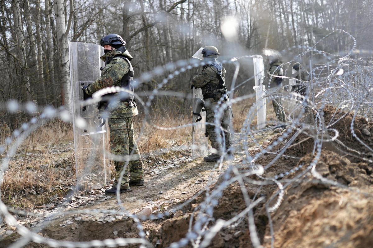 La policía de fronteras de Polonia monta guardia en la valla levantada en el límite con Bielorrusia, en febrero de 2022.