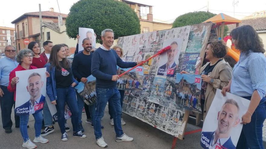 Rodríguez, rodeado de su equipo, pega los carteles del PSOE en la plaza del Templo. | M. J. C.