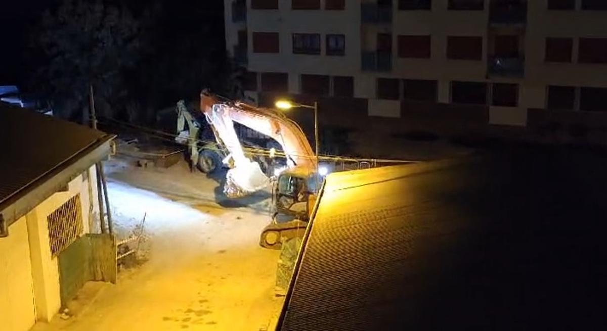 Un tractor trabajando durante la noche en la calle.