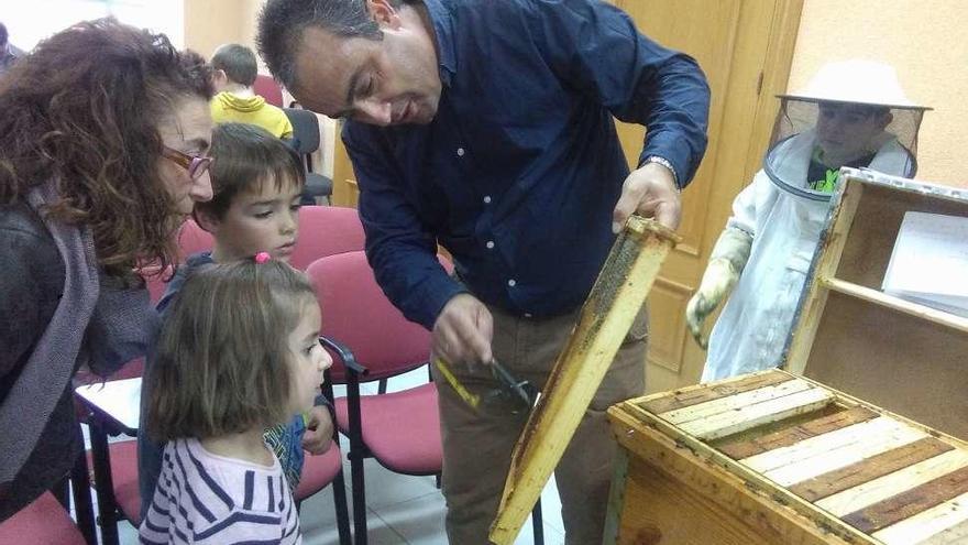 Dos momentos de la conferencia sobre miel en Morales del Vino, a la izquierda Darío Carnero muestra a dos niños un panal y, a la derecha, los pequeños degustan la miel.