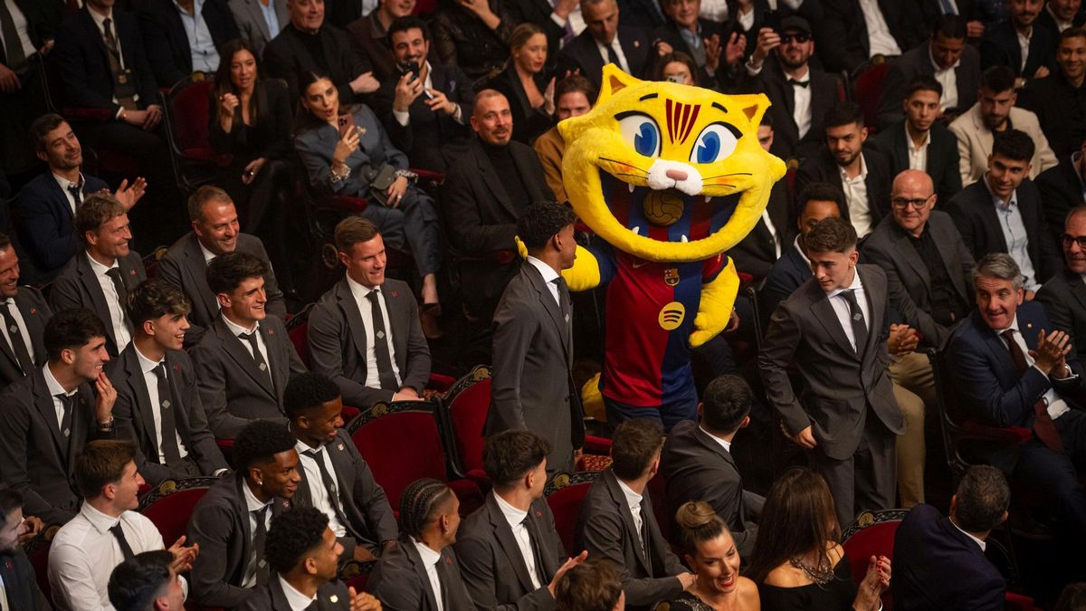 La mascota Cat, en el pasillo central del Liceu, con los jugadores del primer equipo de fútbol.