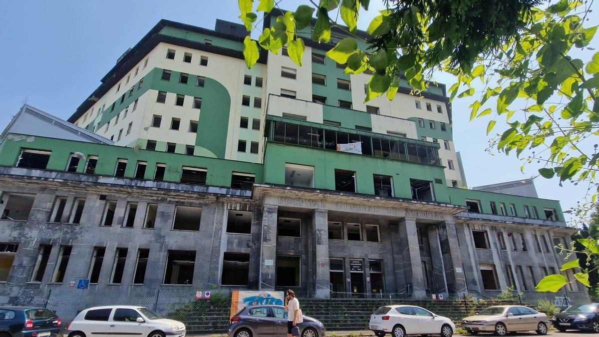 Un viandante pasando por delante del antiguo Hospital General.