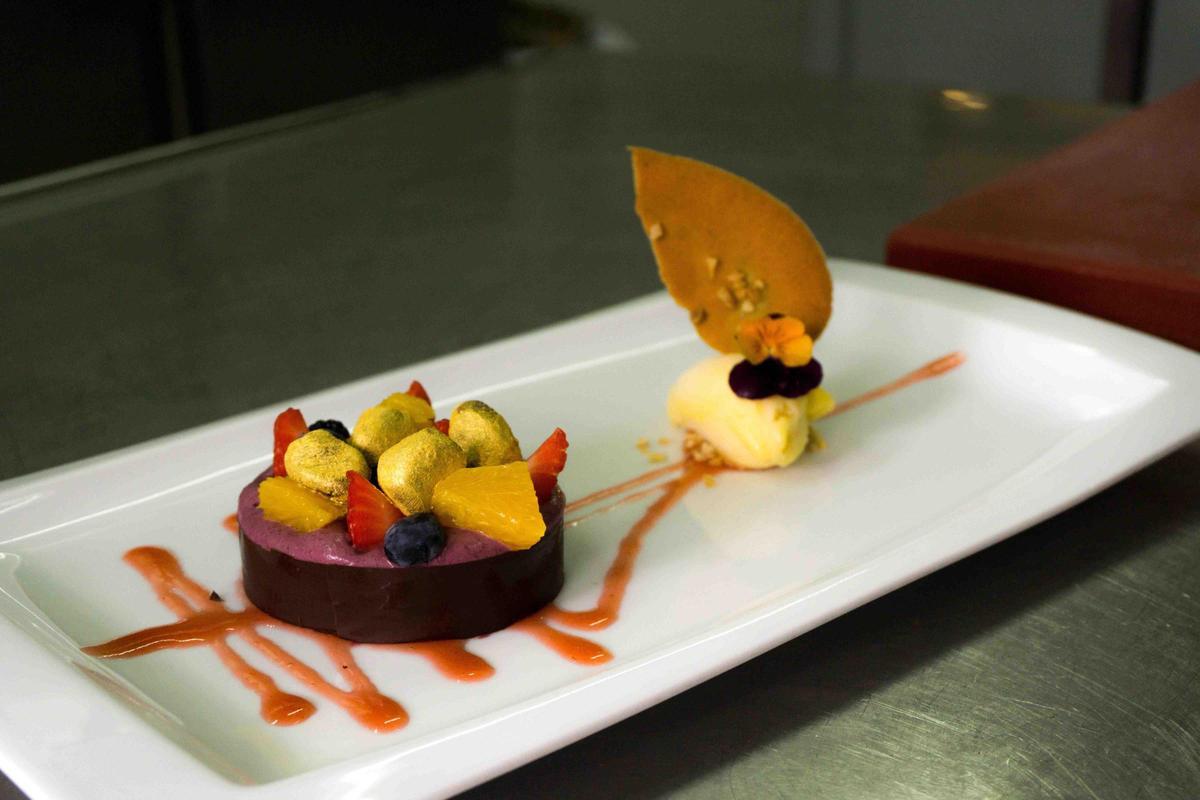Postre de alta cocina presentado con fruta, chocolate y detalles decorativos en Nardi.